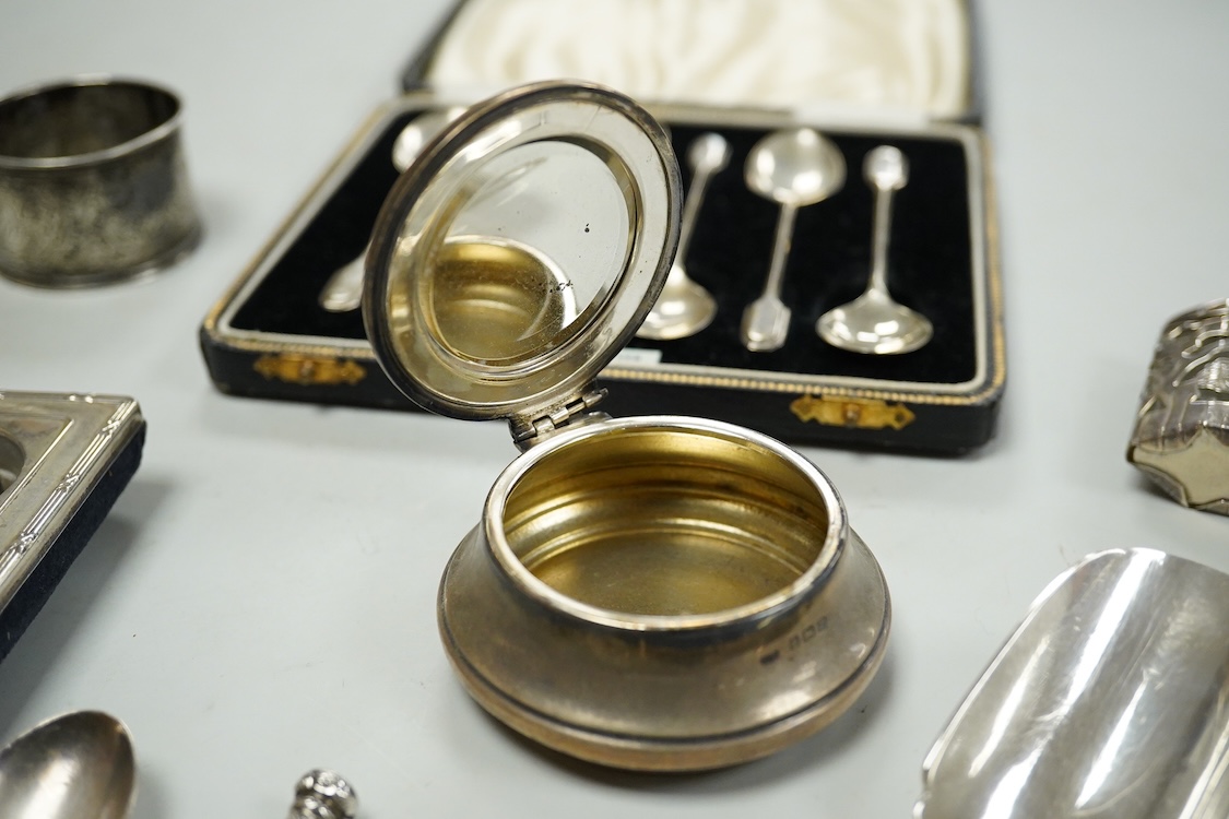 A collection of assorted small silver, including set of six 1930's coffee spoons, a mounted travelling pocket watch case, Victorian pepperette, mounted glass dwarf candlestick, enamelled powder box, Georgian stilton scoo